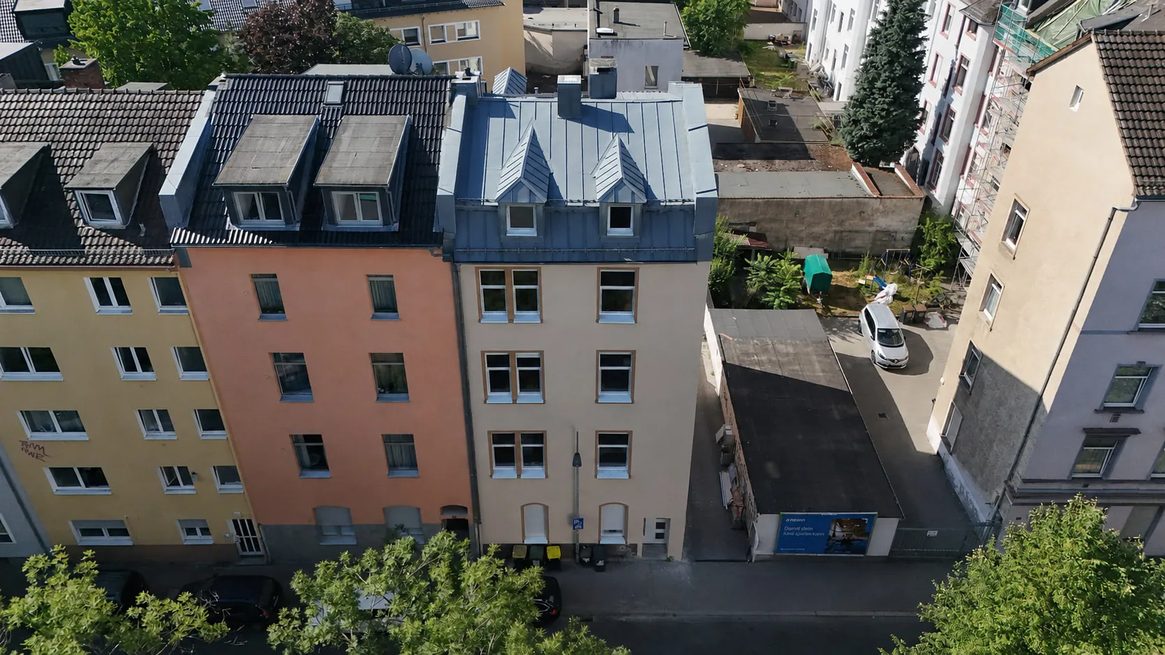 Der Altbau WEST 27 in Schwarzweiß aus der Luft, eingebunden in die geschlossene Häuserzeile mit ihren Hinterhöfen.